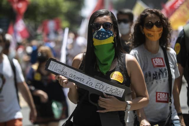 A demonstrator holds a sign with a message that reads in Portuguese: "Education is my weapon" during a protest against President Jair Bolsonaro calling for his impeachment over his government's handling of the pandemic and accusations of corruption in the purchases of COVID-19 vaccines, in Rio de Janeiro, Brazil.