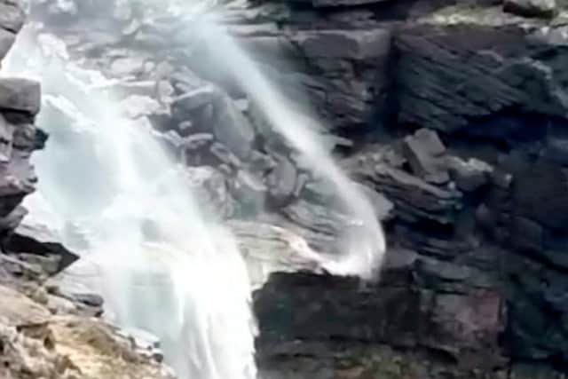 The water appears to flow backwards due to the high winds
