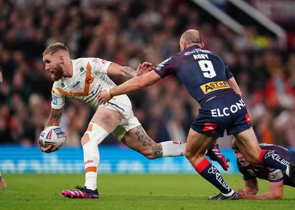 INJURY ISSUES: Catalans Dragons' Sam Tomkins (left) is tackled by St Helens' James Roby at Old Trafford Picture: Zac Goodwin/PA