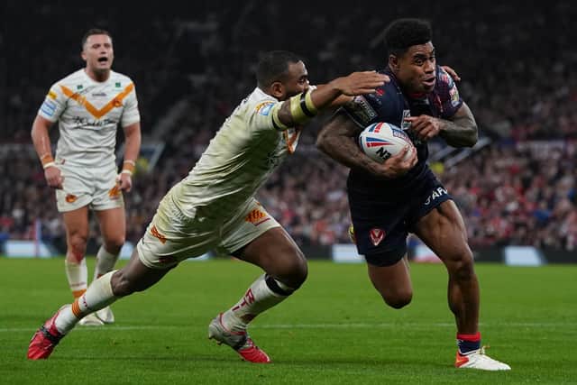 St Helens' Kevin Naiqama (right) evades Catalans Dragons' Samisoni Langi to run in for a try in the Super League Grand Final at Old Trafford Picture: Martin Rickett/PA