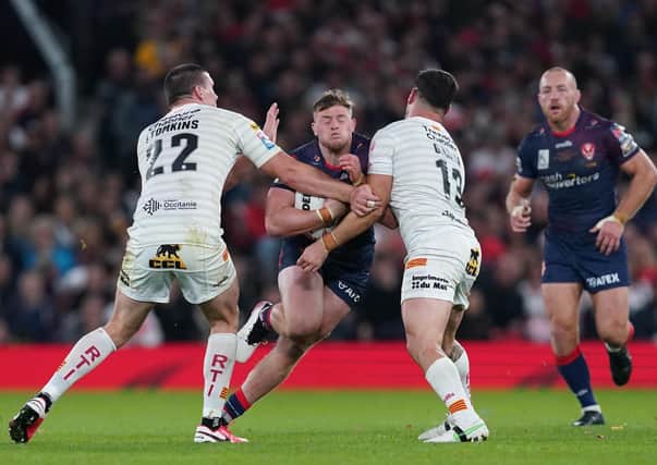 St Helens' Morgan Knowles (centre) is tackled by Catalans Dragons' Joel Tomkins (left) and Ben Garcia at Old Trafford Picture: Martin Rickett/PA