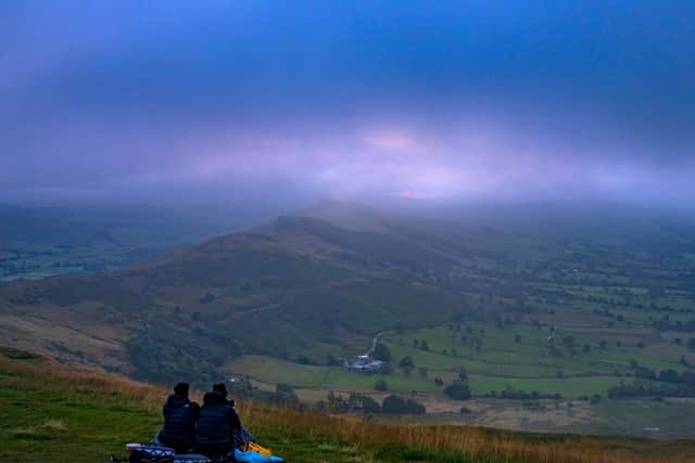A couple make their way to the summit of Mam Tor, in the Peak District, to watch the morning sunrise