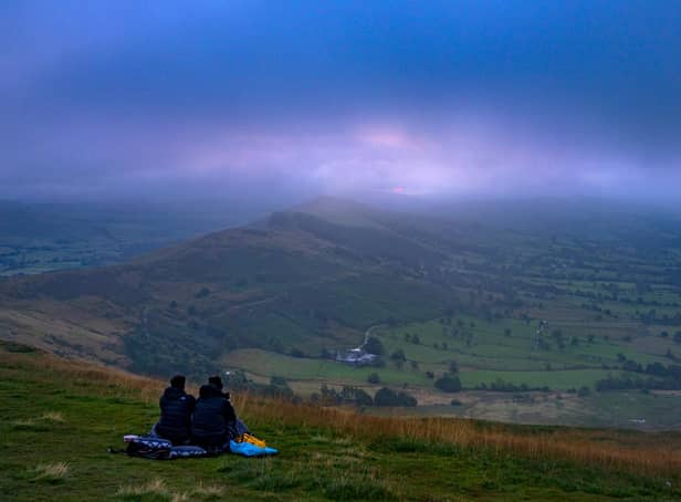 A couple make their way to the summit of Mam Tor, in the Peak District, to watch the morning sunrise
