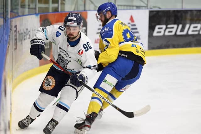 Sheffield Steeldogs' Jonathan Kirk, left, battles on the boards with Leeds Knights forward Adam Barnes. Picture courtesy of Peter Best.