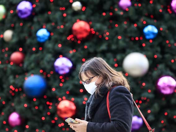 A woman walks past a Christmas tree in Trinity Leeds shopping centre in Leeds. Picture: Danny Lawon/PA Wire.