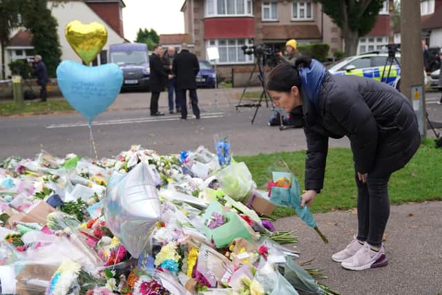 A woman lays flowers at the scene near Belfairs Methodist Church in Eastwood Road North, Leigh-on-Sea, Essex, where Conservative MP Sir David Amess died after he was stabbed several times at a constituency surgery on Friday.