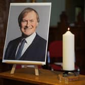 A candle and a photo at a vigil at St Michael & All Angels church in Leigh-on-Sea Essex for Conservative MP Sir David Amess who died after he was stabbed several times at a constituency surgery on Friday.