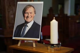 A candle and a photo at a vigil at St Michael & All Angels church in Leigh-on-Sea Essex for Conservative MP Sir David Amess who died after he was stabbed several times at a constituency surgery on Friday.