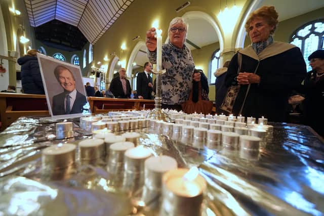 People light candles during a vigil at St Michael & All Angels church in Leigh-on-Sea in Essex for Conservative MP Sir David Amess who died after he was stabbed several times at a constituency surgery on Friday.