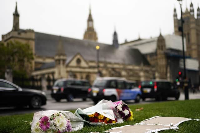 Flowers left in Parliament Square, London, following the death of Conservative MP Sir David Amess after he was stabbed several times at a constituency surgery at Belfairs Methodist Church in Leigh-on-Sea, Essex, on Friday.