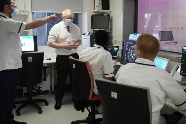 Prime Minister Boris Johnson speaks with staff as he views an MRI scanner during a visit to Leeds General Infirmary in West Yorkshire.
