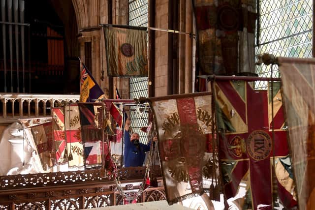 Regimental Flags are lowered in the Regimental Chapel at Beverley Minster..Steve Rial glazier for the minster lowers one of the flags. Image Simon Hulme.