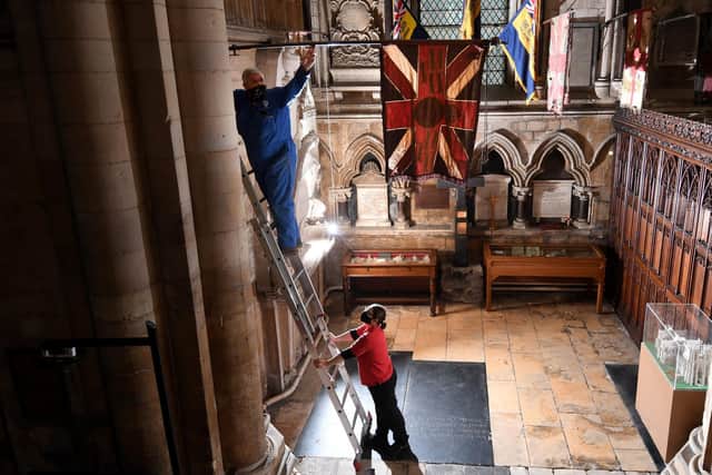 Regimental Flags are lowered in the Regimental Chapel at Beverley Minster..Steve Rial glazier for the minster lowers one of the flags. Image: Simon Hulme