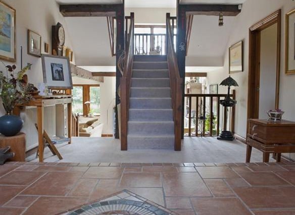 Enter through the solid oak door into into a generous reception hall which is split over two levels. The centre piece of the room is created by the timber staircase and stunning exposed beams.