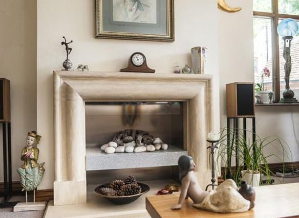The chimney breast houses a living flame log and pebble gas fire which sits on an a Corian granite effect ledge and is surrounded by bespoke sandstone fire surround and hearth.