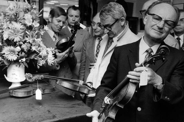 A study in expressions as members of the International Society of Violin and Bow Makers examine some old English violins at an exhibition at L. P. Balmforth and Son's Violin Centre on Merrion Street in May 1973.
