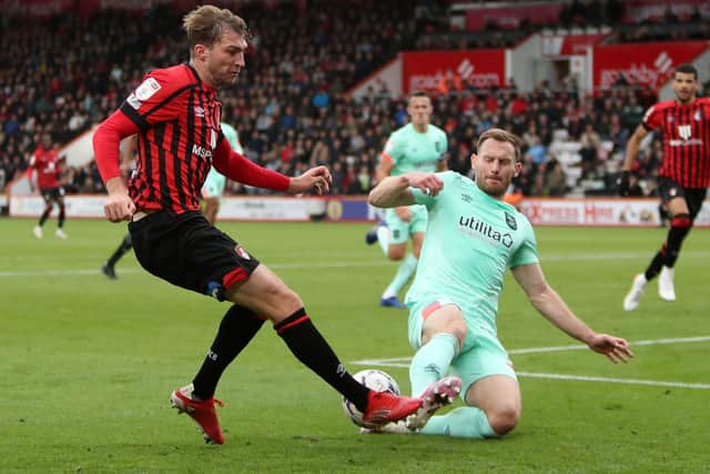 Bournemouth's Jack Stacey (left) and Huddersfield Town's Tom Lees battle for the ball (Picture: PA)