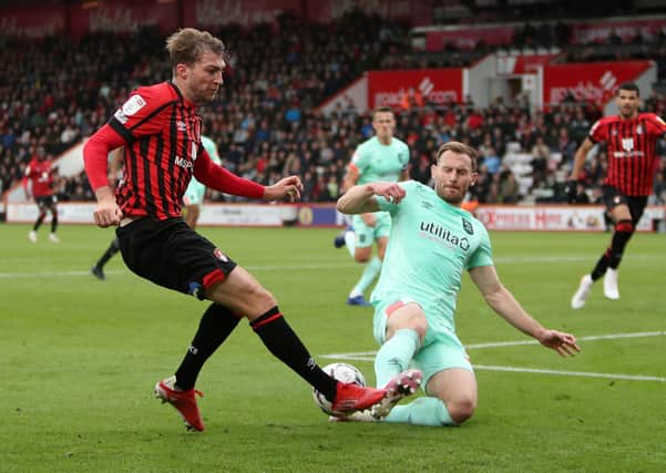 Bournemouth's Jack Stacey (left) and Huddersfield Town's Tom Lees battle for the ball. Picture: Kieran Cleeves/PA