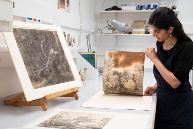 Paper conservator Puneeta Sharma examines Gainsborough’s trees beside a lake, circa 1748-50, which features a large oil stain from the young artist’s studio.
(Picture: The Royal Collection Trust).