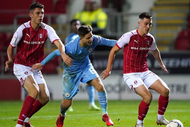 Manchester City's James McAtee (centre) and Rotherham United's Jacob Gratton (right) battle for the ball (Picture: PA)