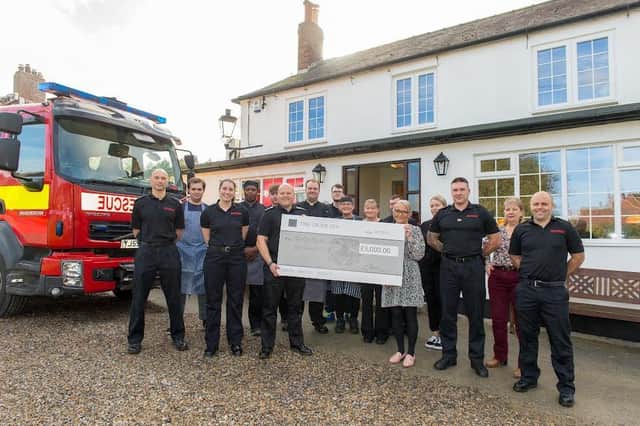 The Tiger staff with the firemen who fought the blaze and a cheque for £5,000