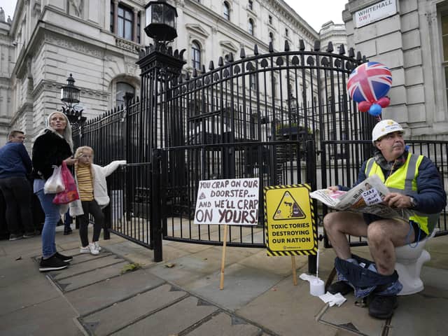 An activist sits on a toilet at the entrance to Downimng Street to protest against raw sewage dumping in the rivers and seas around the UK after leaving the EU