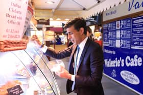 Chancellor of the Exchequer Rishi Sunak visits a stand at the Bury Market (PA)