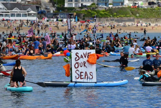 Protesters take part in a paddle out, organised by Surfers Against Sewage