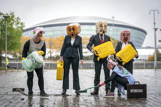 Activists from Ocean Rebellion wearing oil heads with 75-litres of fake oil, in front of the Hydro, Glasgow, as the city prepares for the Cop26 conference. (PA)