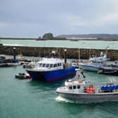 A single boat returns to the harbour at St Helier, Jersey, as fishermen and fisheries on the island wind down trading ahead of political talks and slowly ease off fishing (PA)