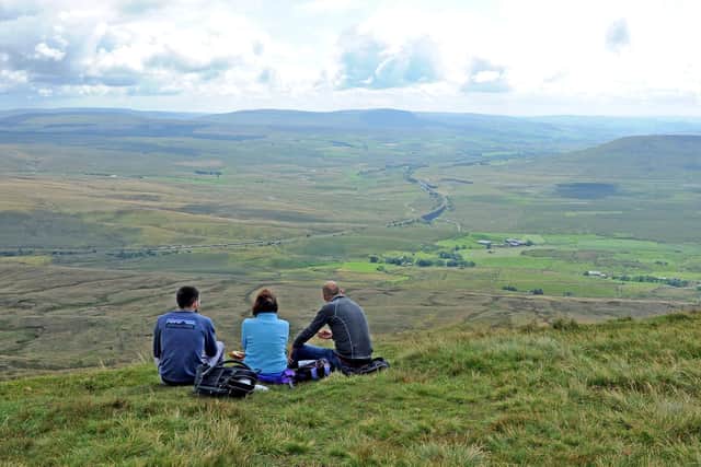 Walkers take a break and lookm down on Ribblehgead from the summit of Whernside