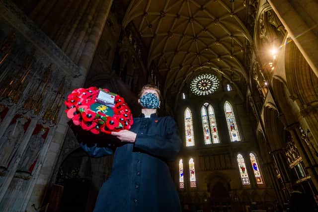 Kirsty Dennett, York Minster Chaplain, holds the wreath from the Yorkshire Regiment. Writer: James Hardisty