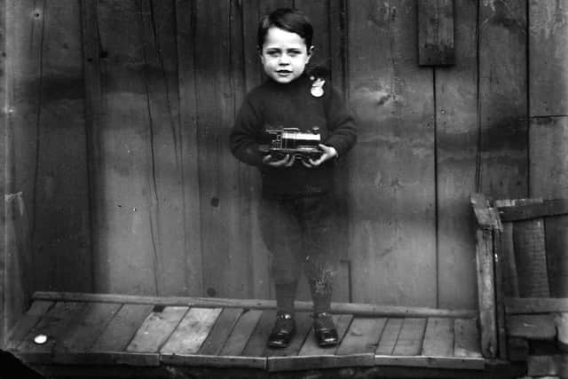 Sidney Stainton, the photographer’s youngest son, pictured for the first time around 1902 when he would have been aged three or four. In one he is clutching a model engine, with a badge on his shoulder that suggests it is near to his birthday.