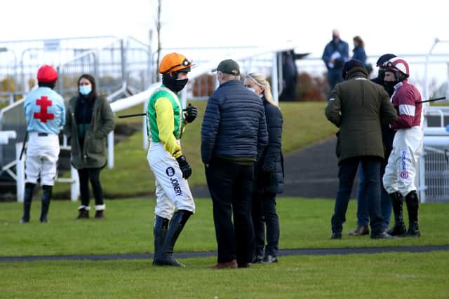 Ryan Mania (orange cap) in the Midnight Shadow colours with trainers Sue and Harvey Smith at Wetherby.