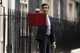 Britain's Chancellor of the Exchequer, Rishi Sunak holds the budget box as he departs 11 Downing Street, ahead of delivering his Autumn Budget and Spending Review to Parliament, on October 27, 2021. Photo by Dan Kitwood/Getty Images.