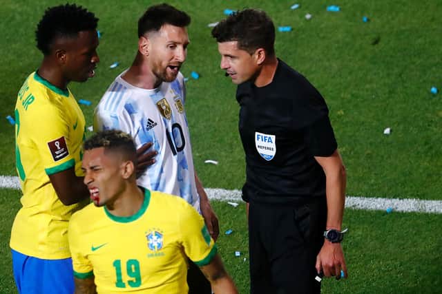 CUT OPEN: The damage to Raphinha's lip is seen as Messi speaks to the referee. Picture: Getty Images.