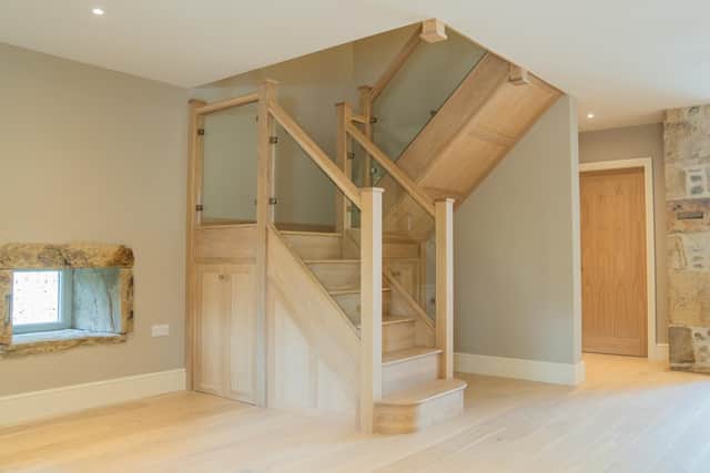 The timber and glass staircase fits well with the barn's aesthetic