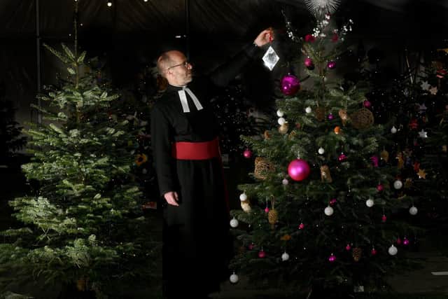 The Rev Michael Smith Canon Pastor at York Minster finishing off decorating the York Minster Christmas Tree at the York Minster Christmas Tree Festival , with the decorations made by the York Minster Glaziers and Stonemasons. .Image: Gary Longbottom