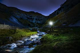 A walker with a head torch at Gordale Scar