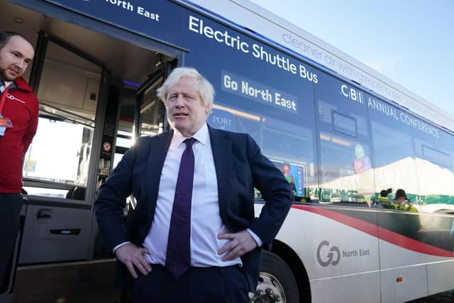 Prime Minister Boris Johnson looks at a new electric shuttle bus as he leaves the Port of Tyne, in South Shields