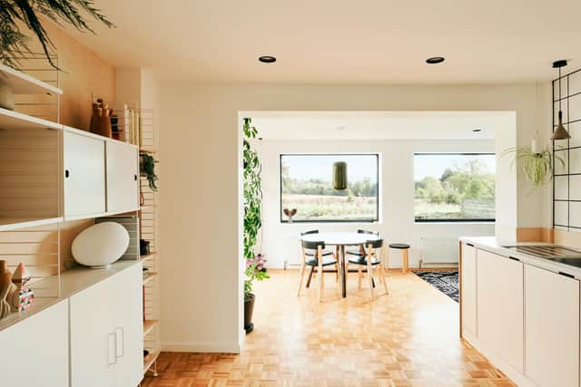 The open plan kitchen/dining area with parquet flooring and String units (left)