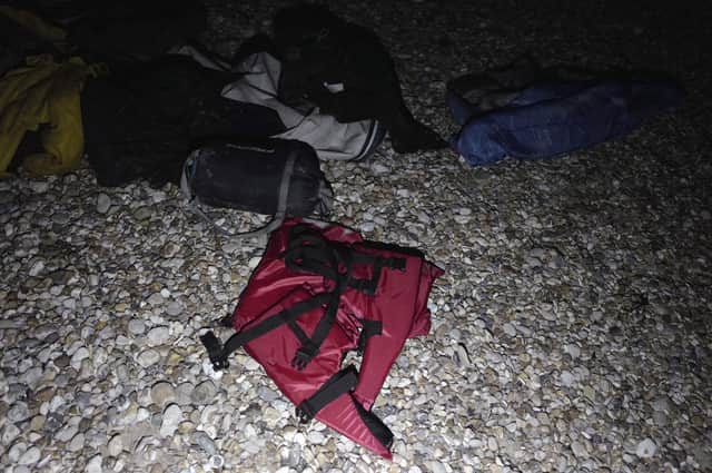 Life jackets, sleeping bags and damaged inflatable small boat are pictured on the shore in Wimereux, northern France, Friday, Nov. 26, 2021 in Calais, northern France. Children and pregnant women were among at least 27 migrants who died when their small boat sank in an attempted crossing of the English Channel, a French government official said Thursday. (