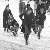 Whitby's winters past... children playing in the snow in wheelbarrows. Image by former press photographer John Tindale, revealed as his old recovered audio tapes are turned into a new film for Whitby Museum.
