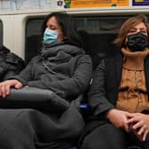 People wearing masks traveling on the London Underground.