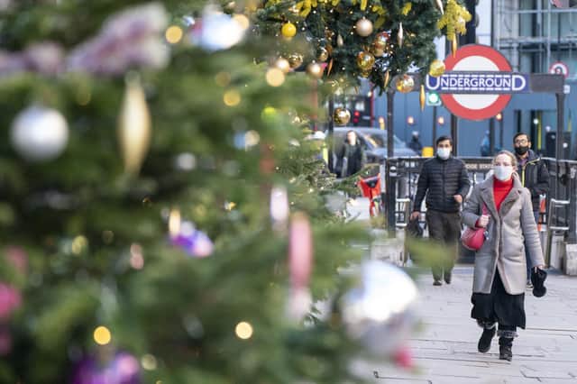 Pedestrians wear masks as they walk past Christmas decorations in London's Knightsbridge