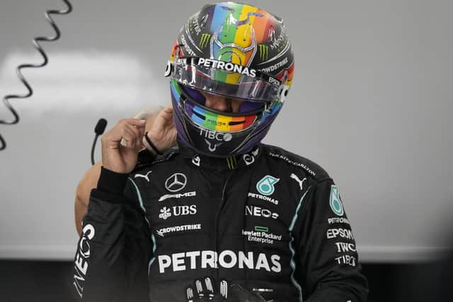 Mercedes driver Lewis Hamilton of Britain adjusts helmet during practice session for the Saudi Arabian Grand Prix in Jiddah, Friday, Dec. 3, 2021. (AP Photo/Hassan Ammar)