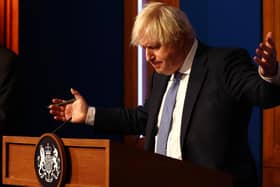 Prime Minister Boris Johnson gestures whilst speaking at a press conference in London's Downing Street after ministers met to consider imposing new restrictions in response to rising cases and the spread of the Omicron variant.