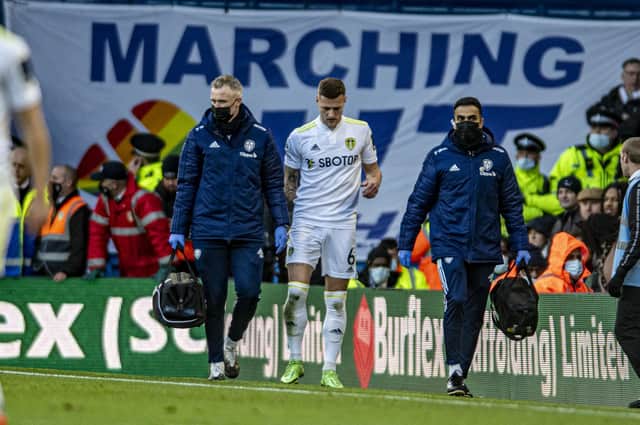 MARCHING OFF TOGETHER: Leeds United captain Liam Cooper leaves the field with a hamstring injury during the match against Brentford