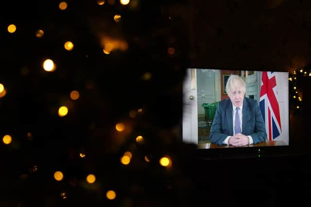 Prime Minister Boris Johnson appears on a TV screen during a pre-recorded address to the nation from Downing Street, about the booster vaccine programme.