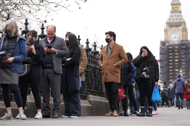 People queuing on Westminster Bridge for booster jabs at St Thomas' Hospital, London. Everyone over 18 in England will be offered booster jabs from this week, Prime Minister Boris Johnson said on Sunday night, as he declared an "Omicron emergency".